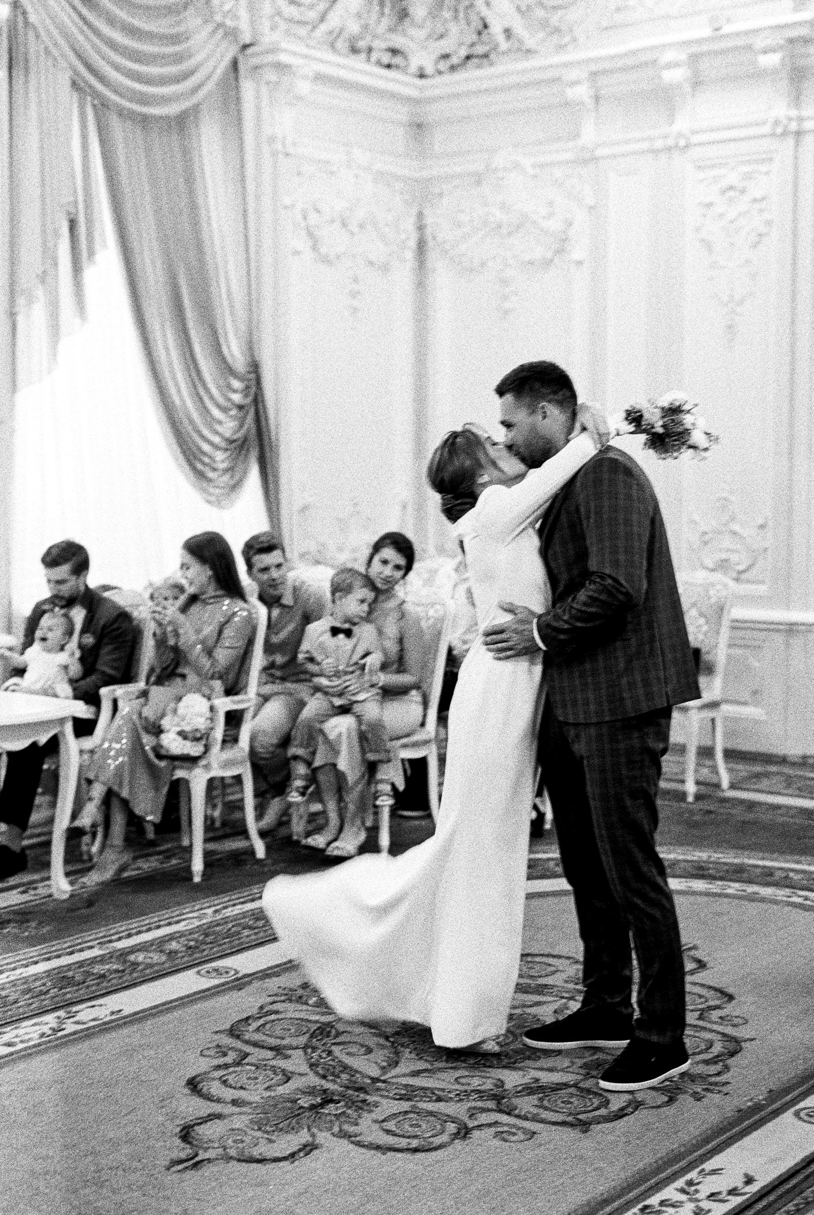 A couple sharing their first dance surrounded by guests