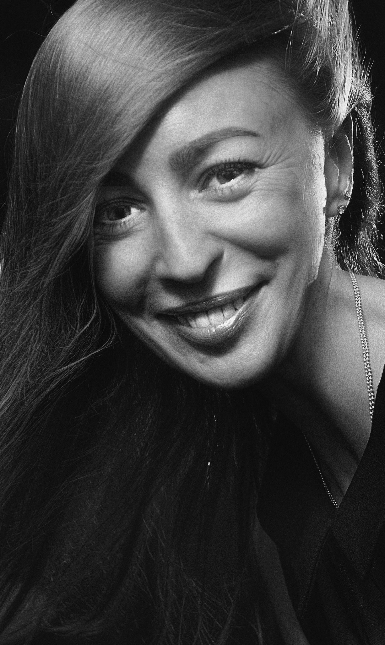 A smiling black-and-white close-up portrait