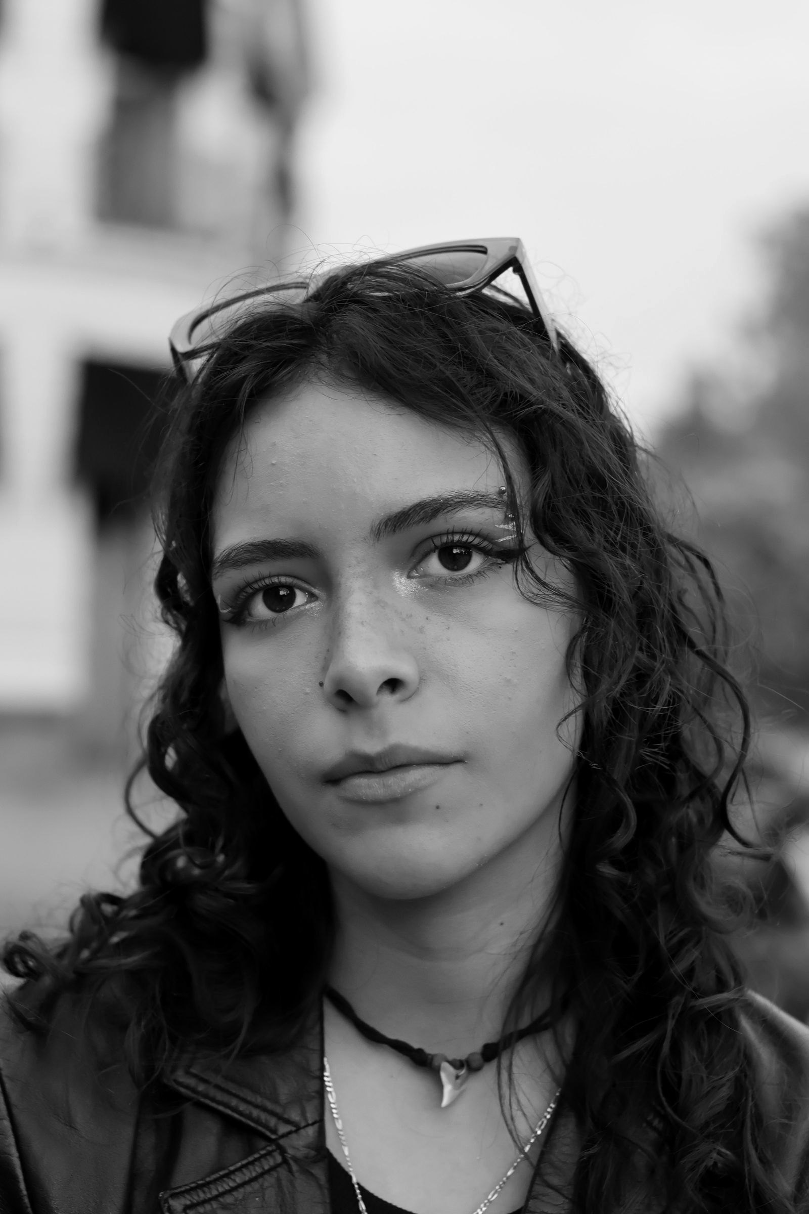 A guest with curly hair and glasses looking into the camera