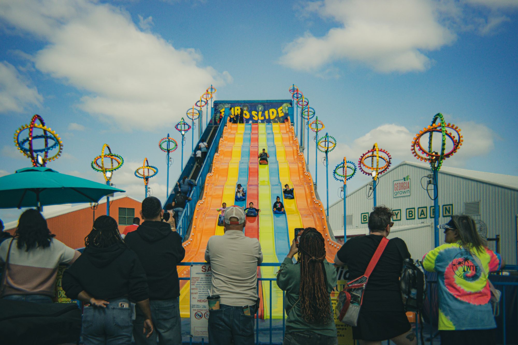 Guests lining up for a giant rainbow inflatable slide