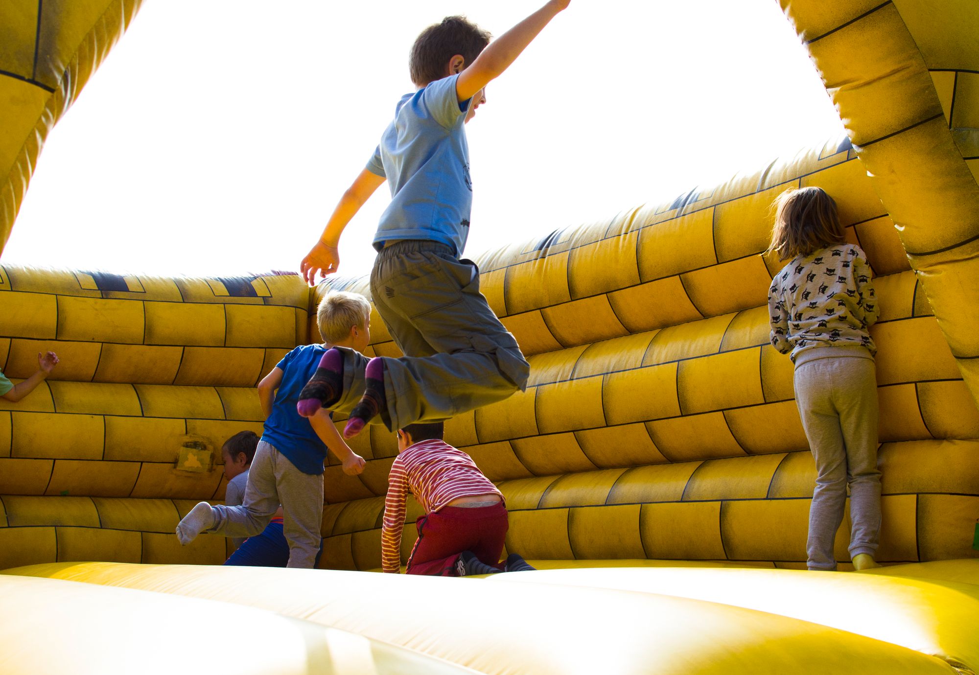 Kids jumping in a yellow bounce house