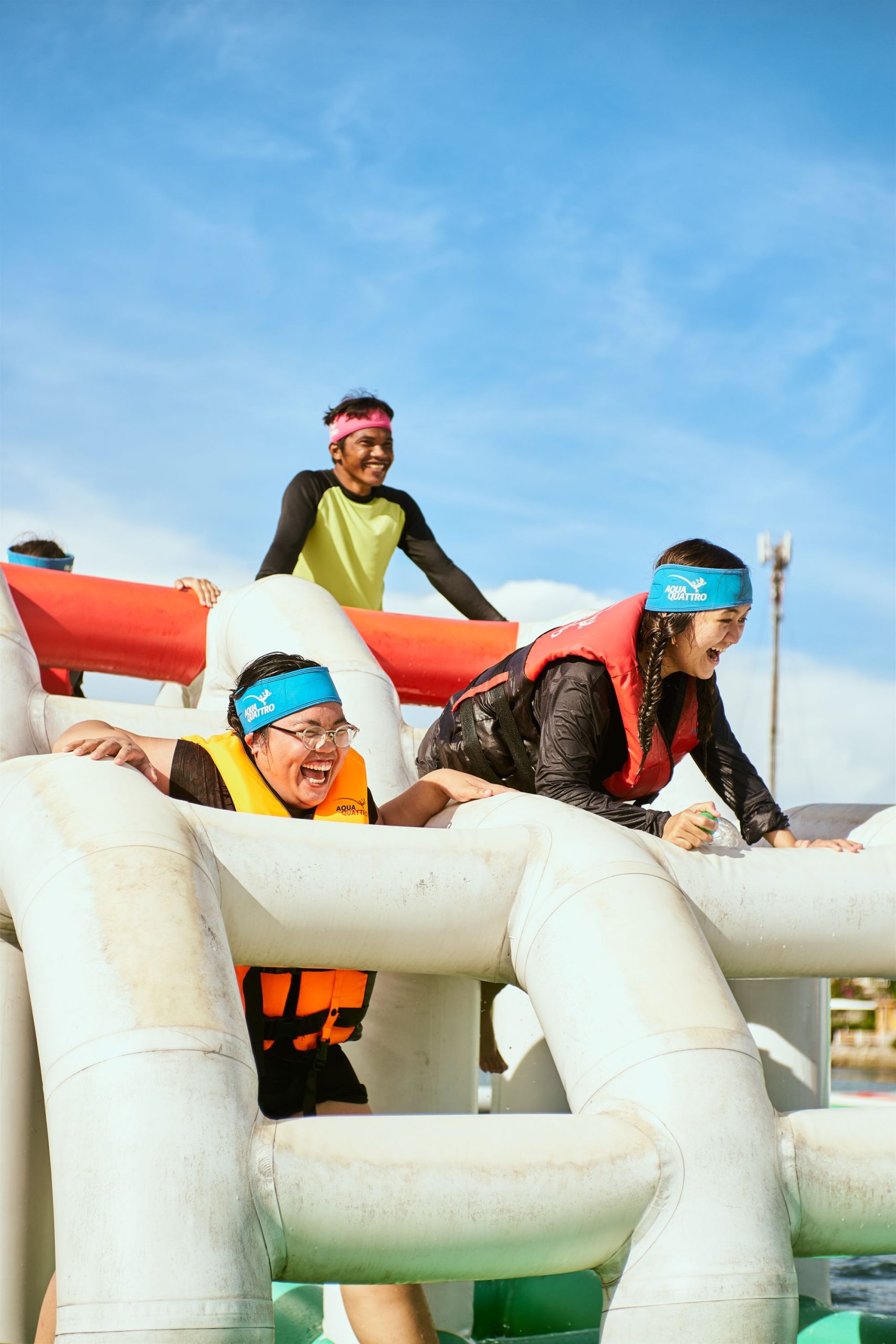 Teammates laughing on an inflatable obstacle course
