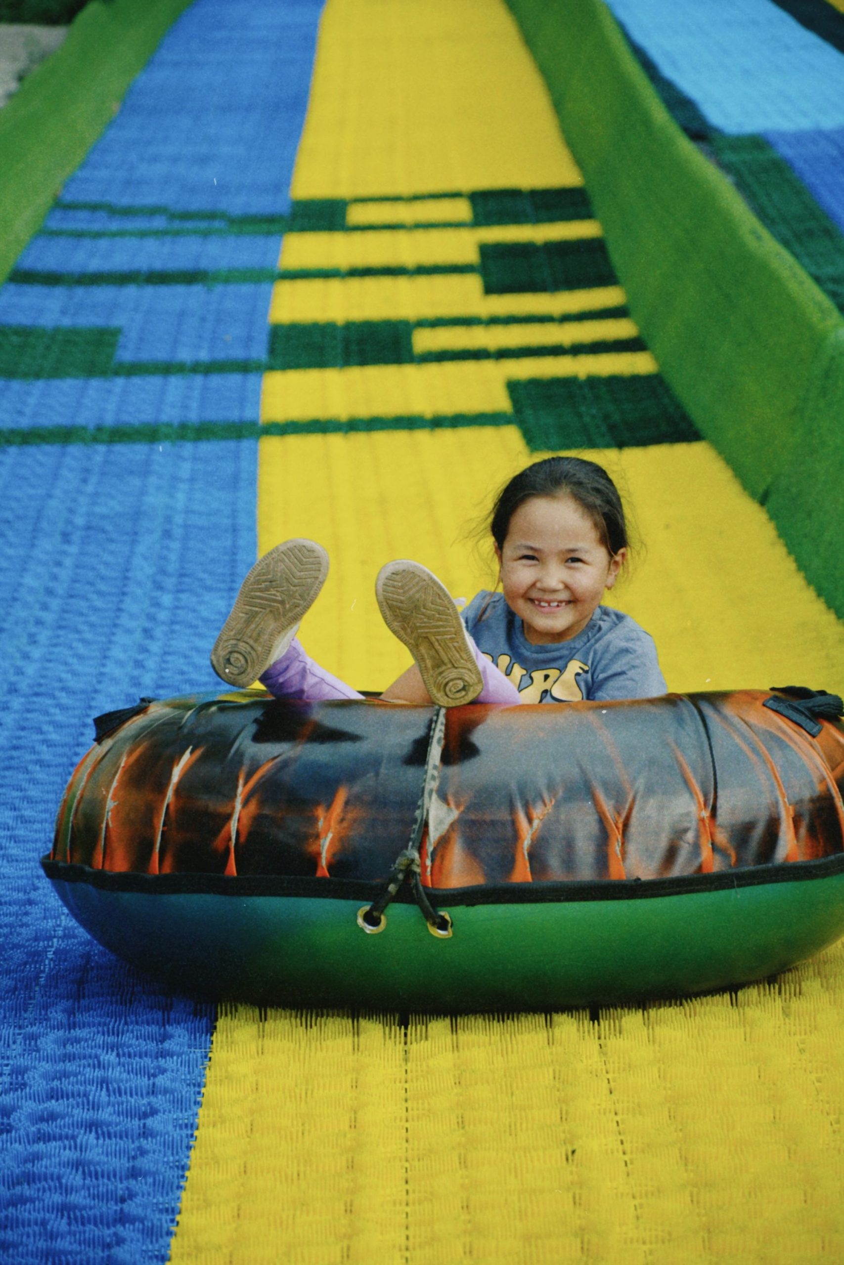 A smiling girl lying on a colorful inflatable