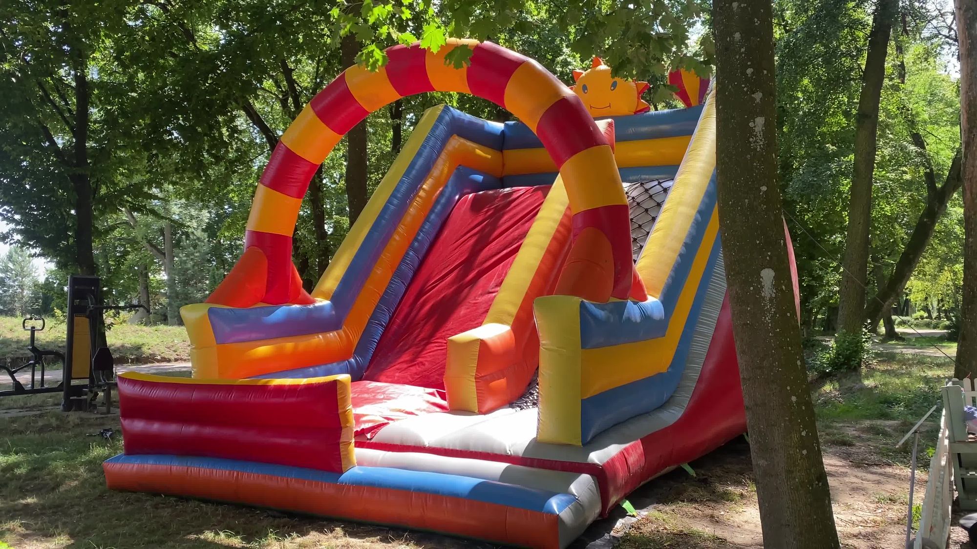 A red and yellow inflatable water slide among trees