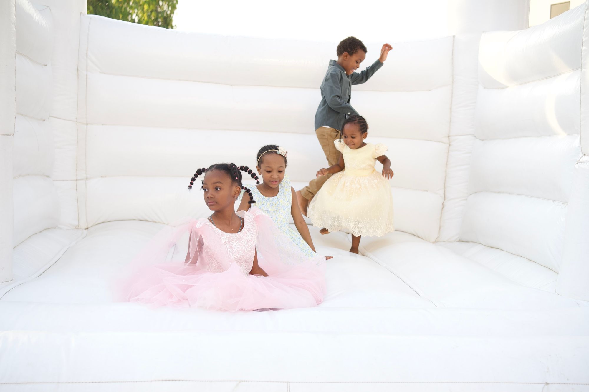 Two little girls jumping in a white bounce house