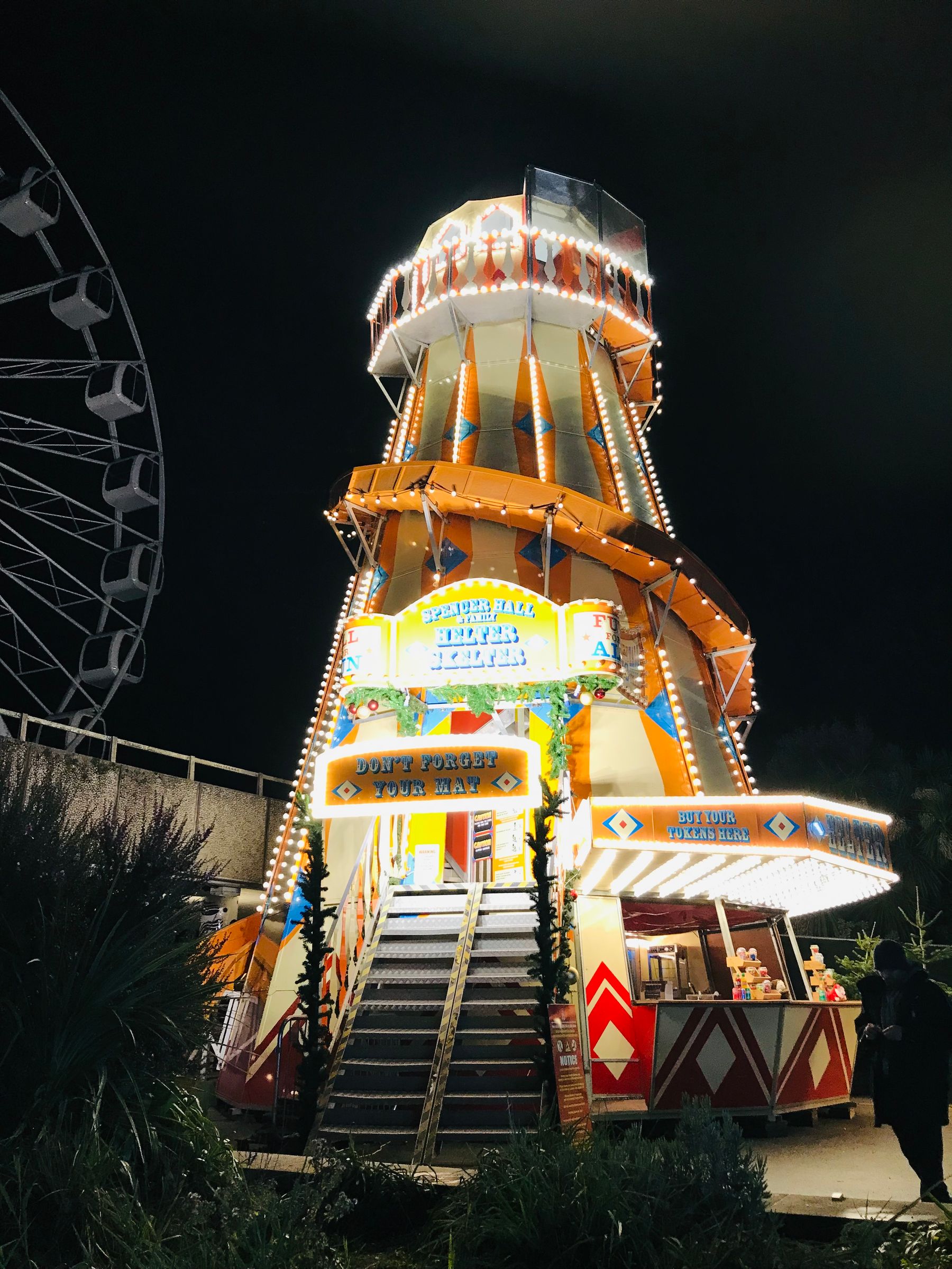 A helter-skelter slide lit up at night