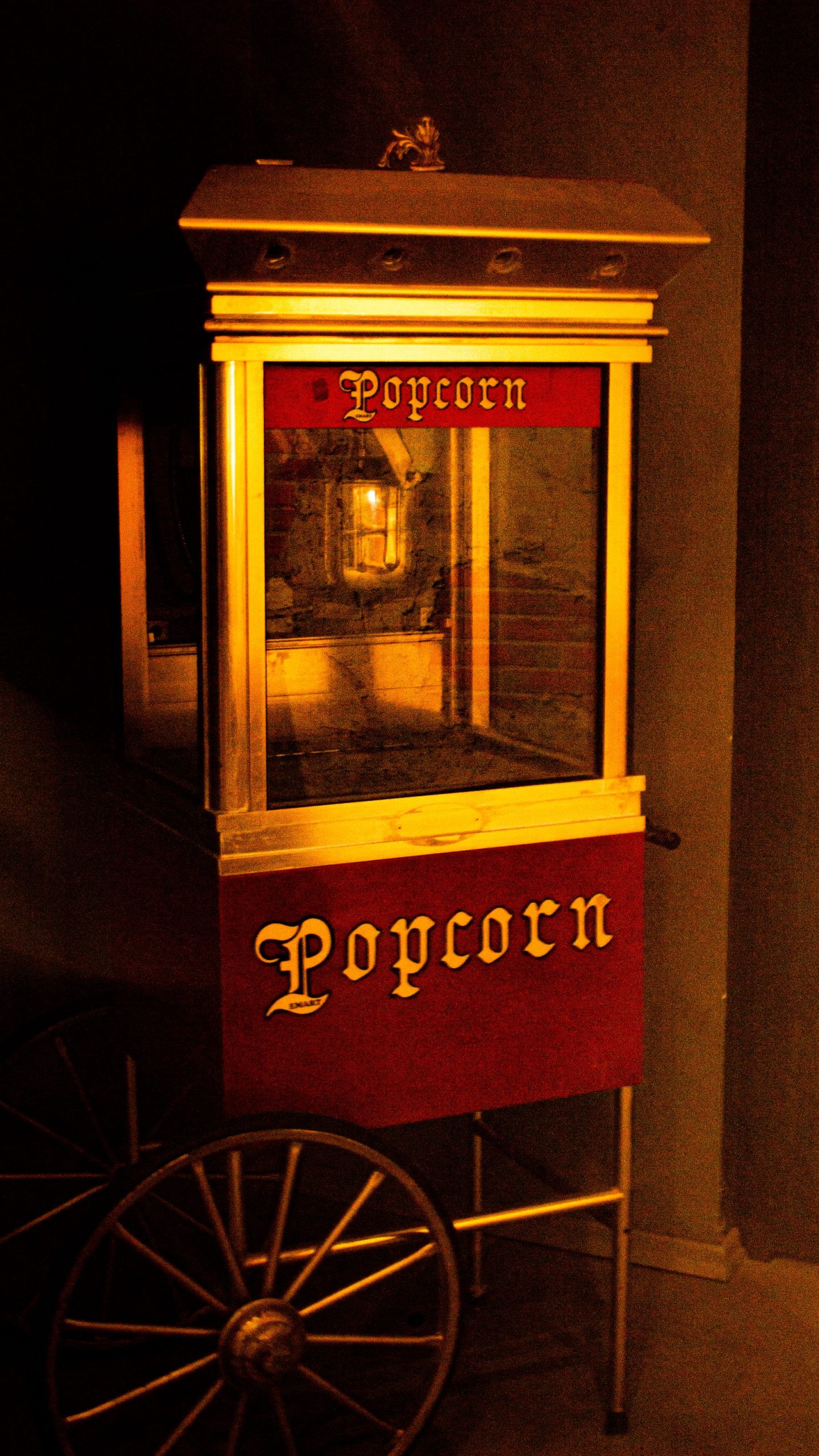 A vintage popcorn cart glowing at night