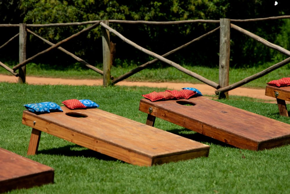 Two cornhole boards on a green lawn
