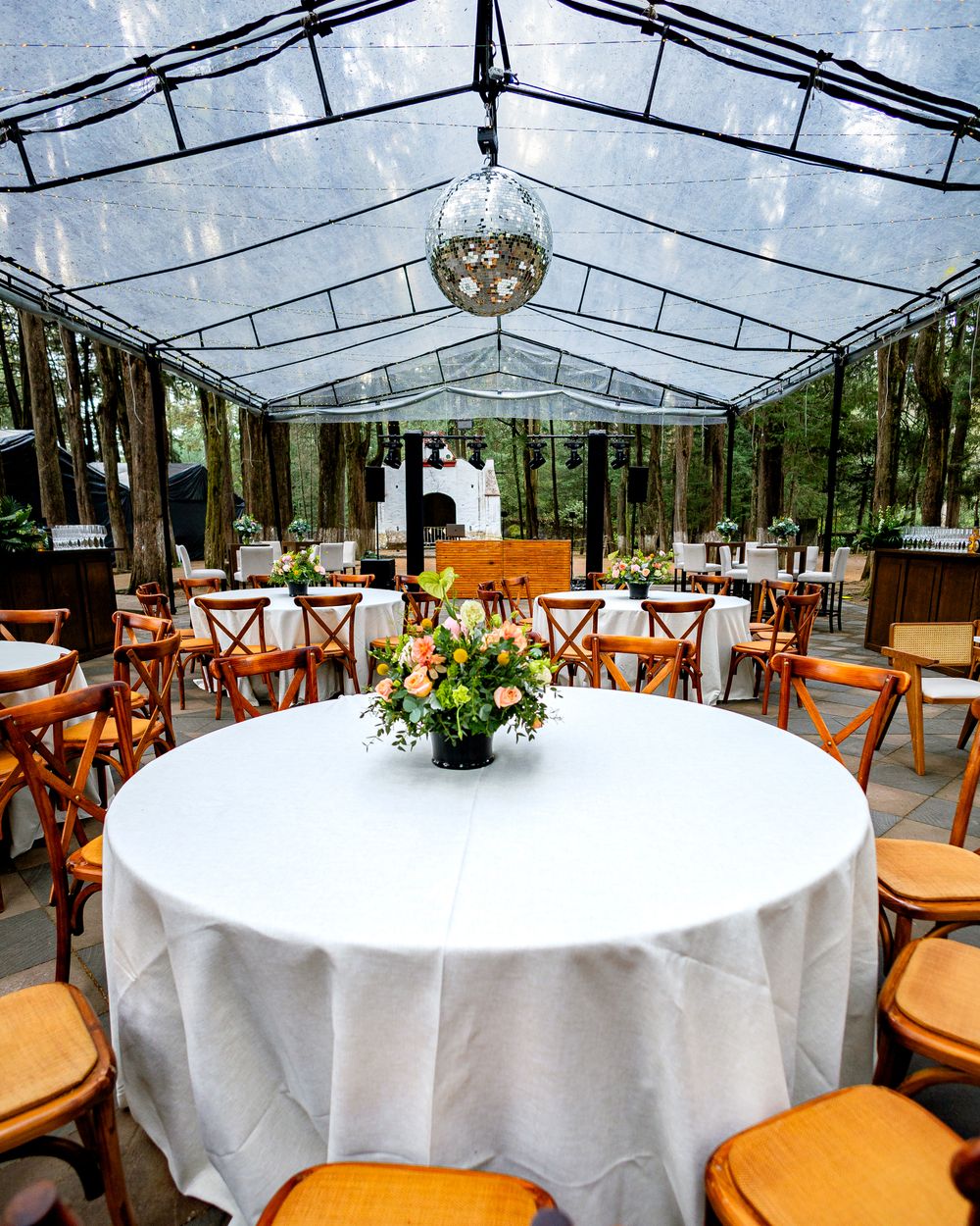 A clear party tent with tables and chairs