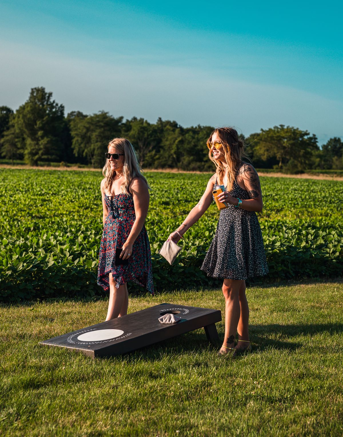 Two friends playing cornhole on a lawn