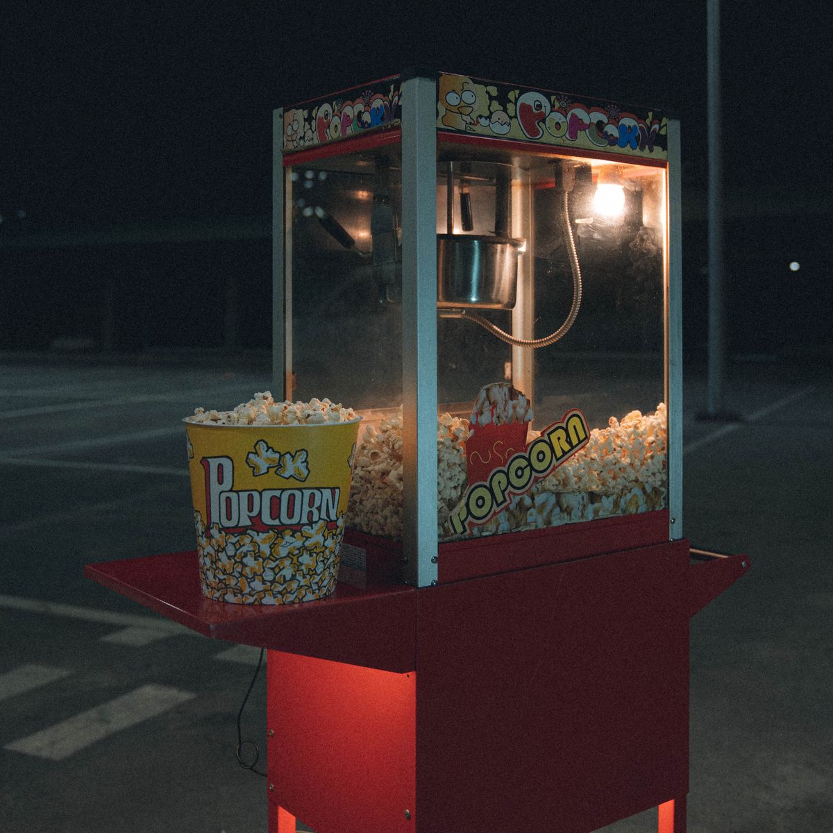A popcorn machine glowing at an evening party