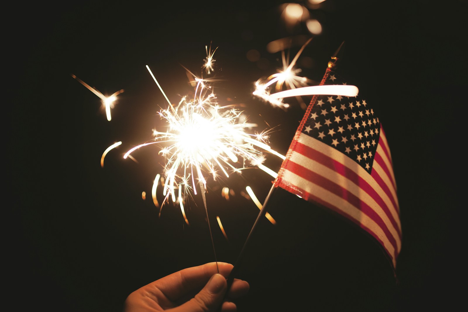 A sparkler next to an American flag