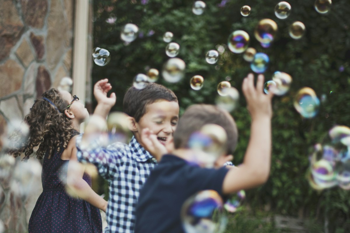 Kids playing with bubbles in a backyard