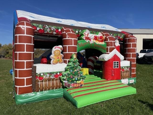 A Christmas wonderland bounce house with chimneys and a tree