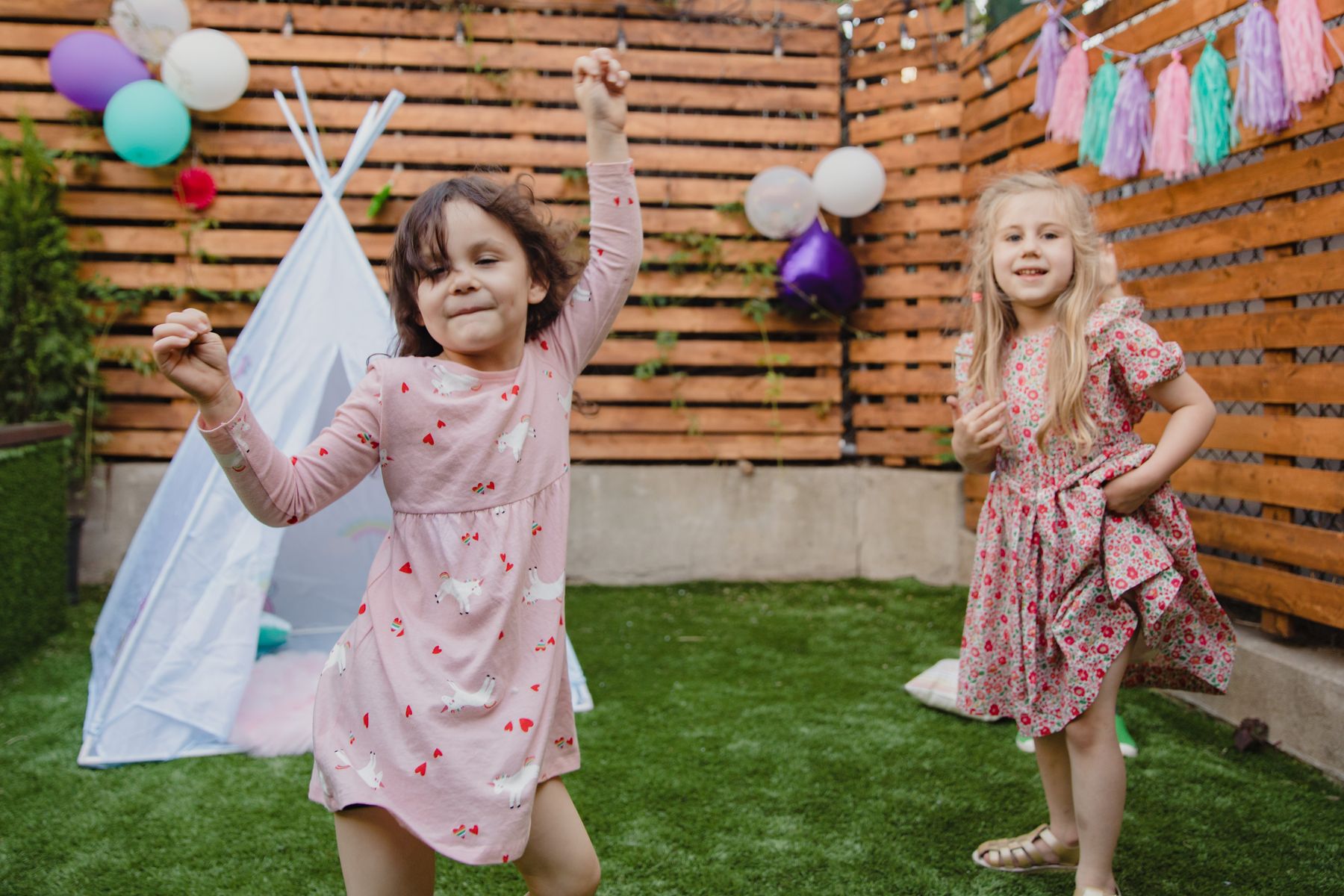 A little girl dancing at a backyard birthday party