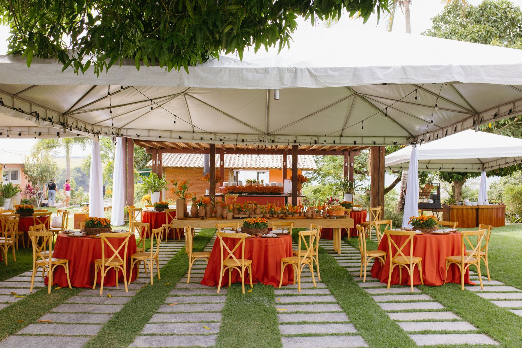 A white party tent over tables and chairs in a garden