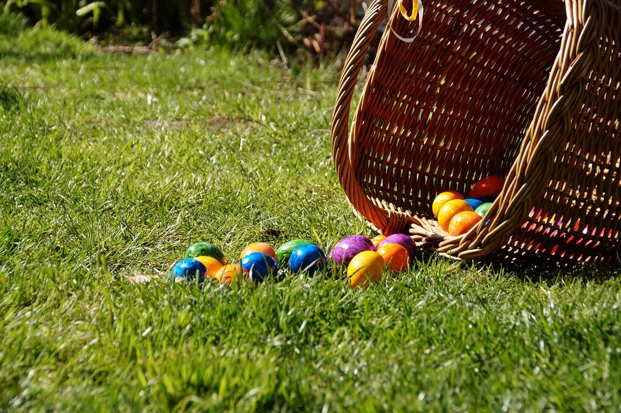 A basket of Easter eggs tipped over in the grass