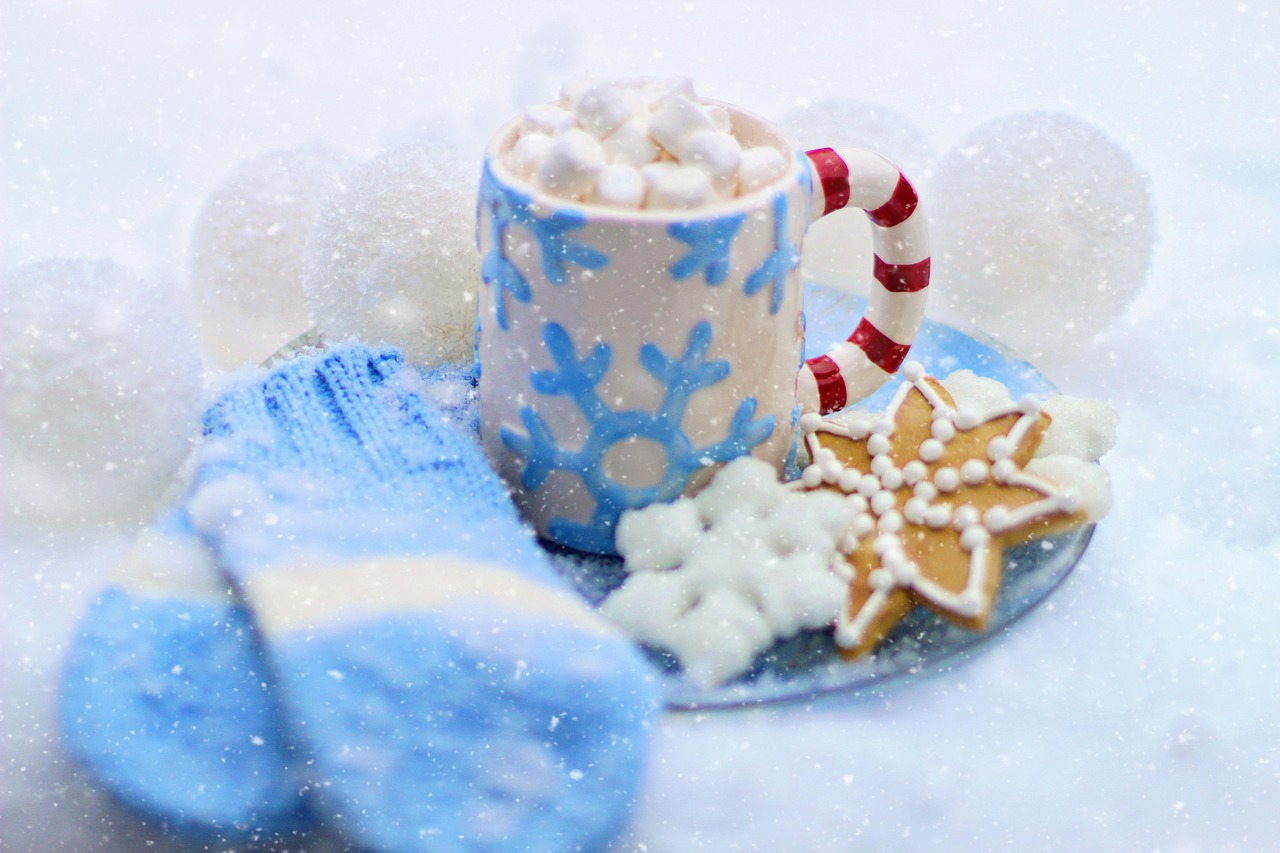 Cocoa with marshmallows beside knit mittens
