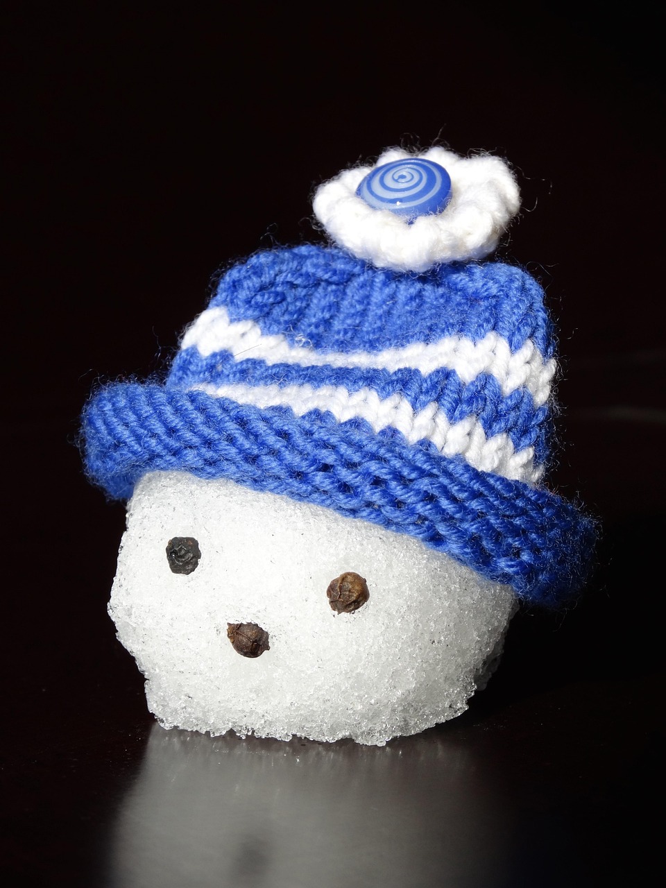 A snowman wearing a blue knit hat