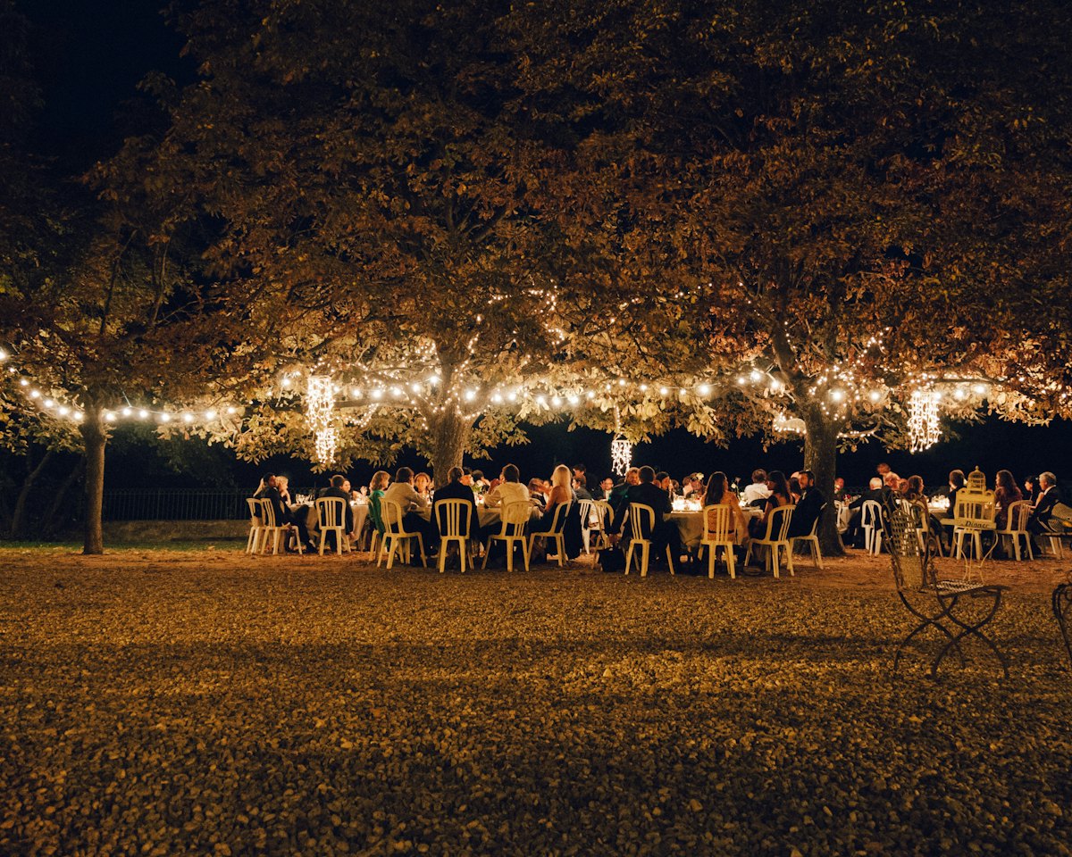 Outdoor wedding dinner under bistro lights