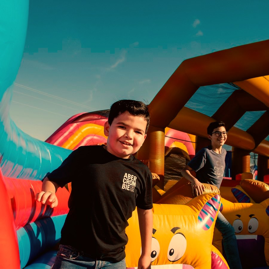 A smiling boy on a colorful inflatable combo
